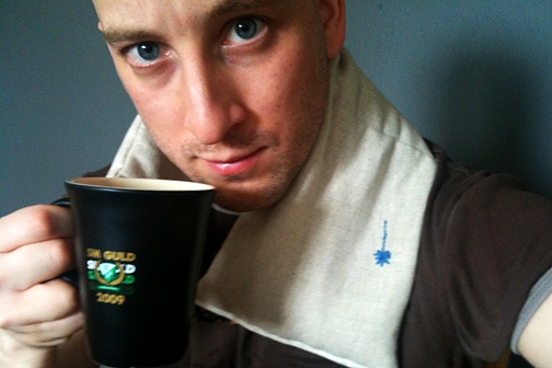 Vetekudde mot öm nacke och en mugg kaffe.